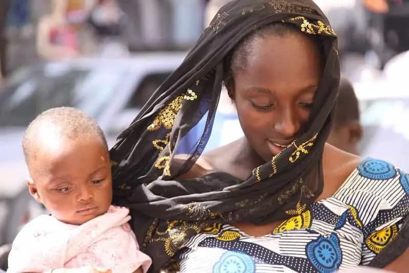 Une mère et son bébé dans une rue de Dakar