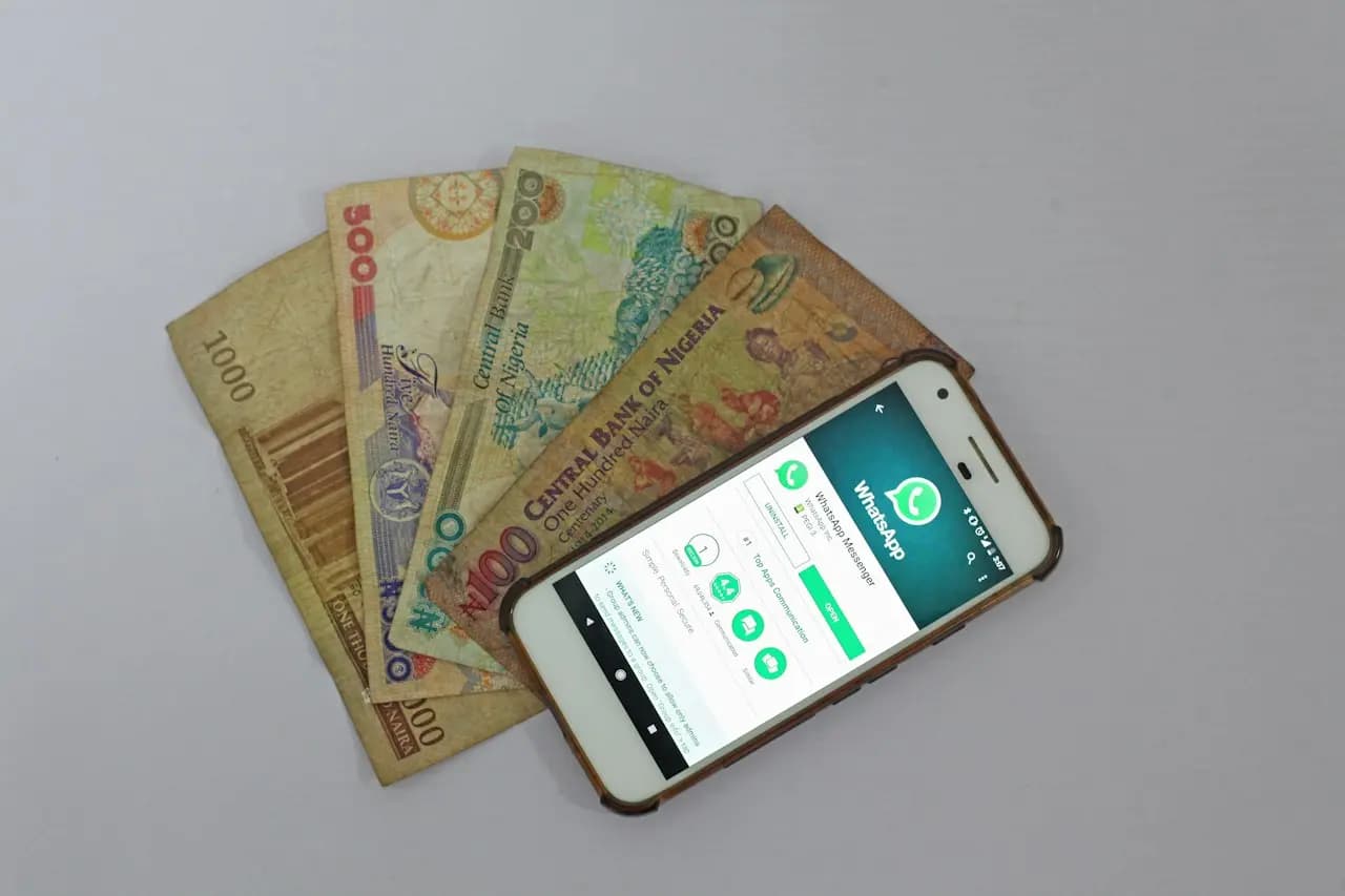 Smartphone posé à côté de billets de banque, symbole du paiement mobile