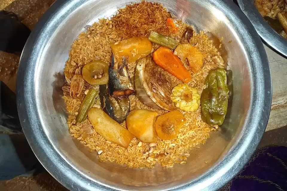 Bol de ceebu jën : riz rouge, poisson et légumes (carotte, chou, manioc, gombo) servis dans un plat commun