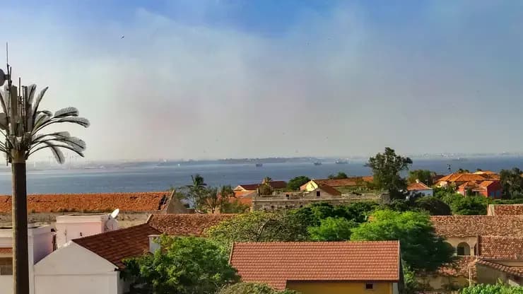 Toits de tuiles des maisons de l'île de Gorée avec la baie de Dakar en arrière-plan