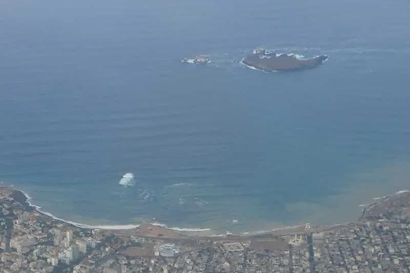 Vue aérienne de la côte de Dakar avec l'île de la Madeleine au large, entourée d'eaux bleues