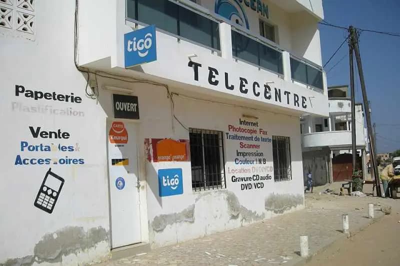 Télécentre de quartier à Yoff, à Dakar : façade blanche annonçant internet, photocopie et vente de portables et accessoires