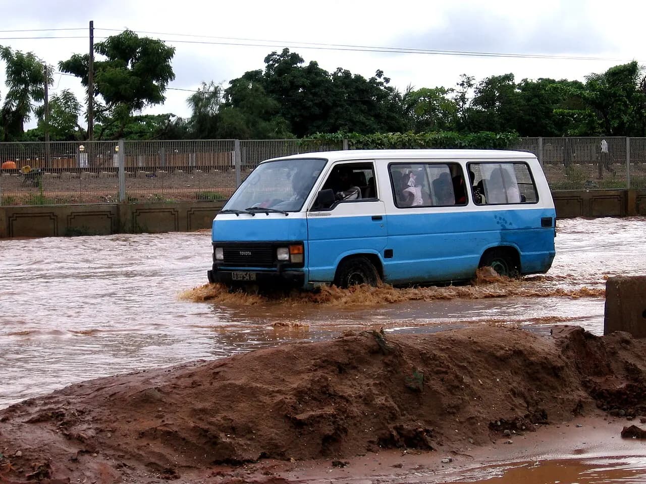 Minibus traversant une route inondée après de fortes pluies