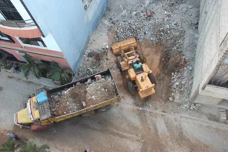 Chargeur et camion déblayant un terrain pour la construction d'un immeuble à Ngor, Dakar