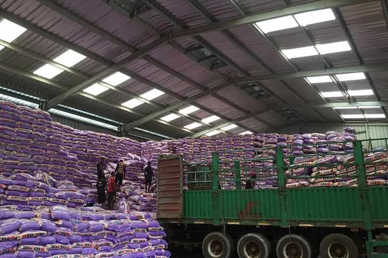 Ouvriers déchargeant des sacs de riz d'un camion dans un entrepôt de Dakar