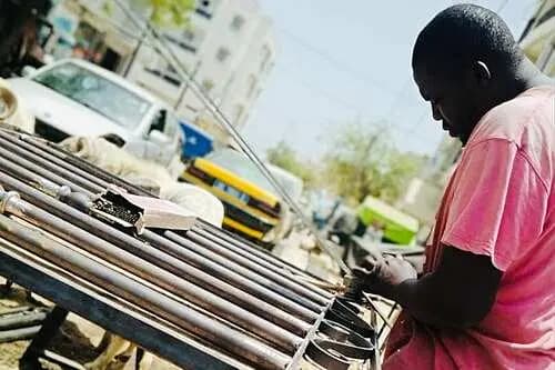 Artisan soudeur assemblant un portail métallique dans la Médina de Dakar