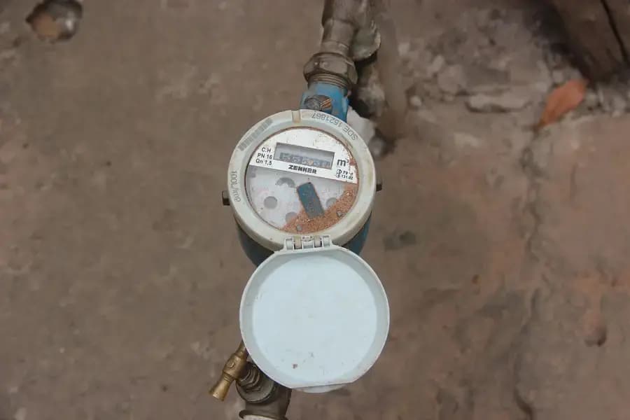 Compteur d'eau domestique fixé au mur, index de consommation en mètres cubes visible