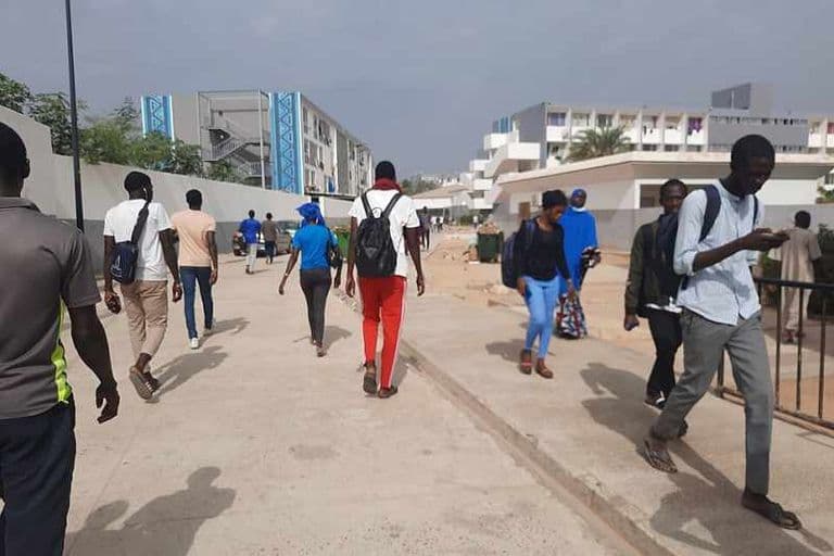Étudiants marchant entre les bâtiments du campus de l'université Cheikh Anta Diop à Dakar