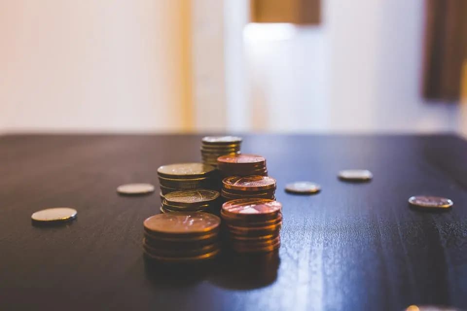 Piles de pièces de monnaie sur une table, symbole d'épargne et de financement