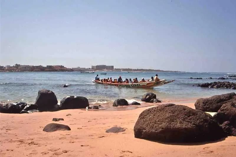 Pirogue chargée de passagers près de la plage rocheuse de l'île de Ngor, face à la côte de Dakar