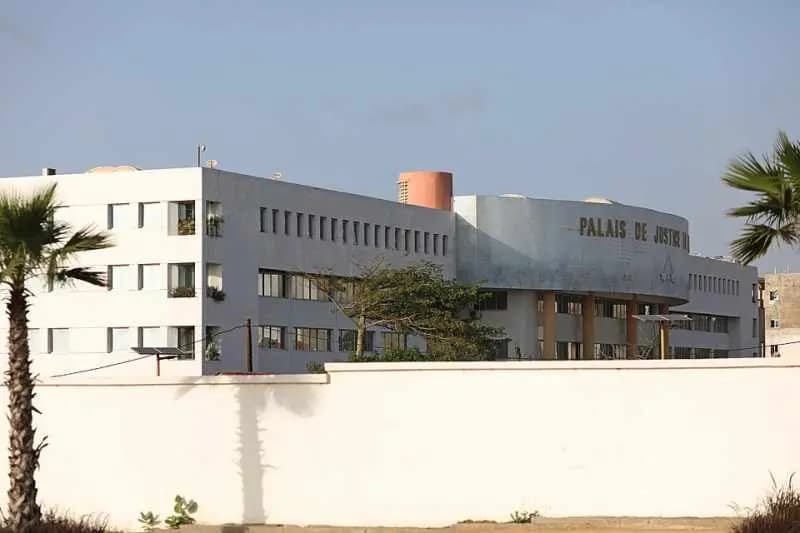 Palais de justice de Dakar : bâtiment blanc à la façade arrondie, bordé de palmiers