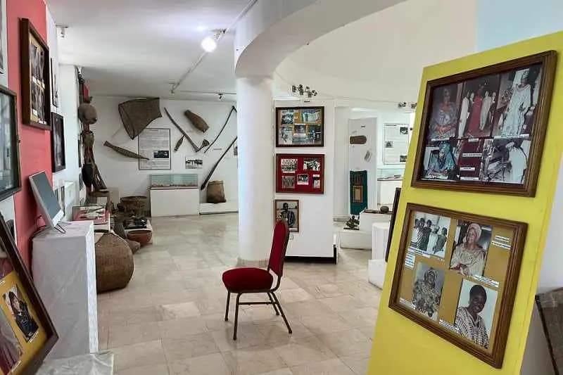 Salle d'exposition du Musée de la Femme Henriette Bathily à Dakar : photographies encadrées, objets traditionnels et mannequins en tenue