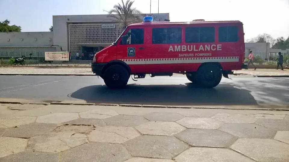 Ambulance rouge des sapeurs-pompiers du Sénégal, vue de profil dans une rue de Thiès