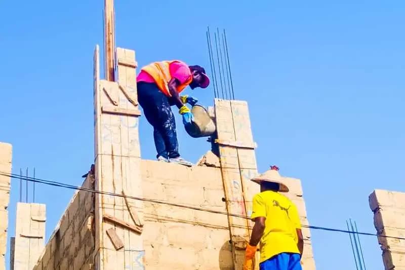 Ouvriers travaillant en hauteur sur un chantier de construction au Sénégal