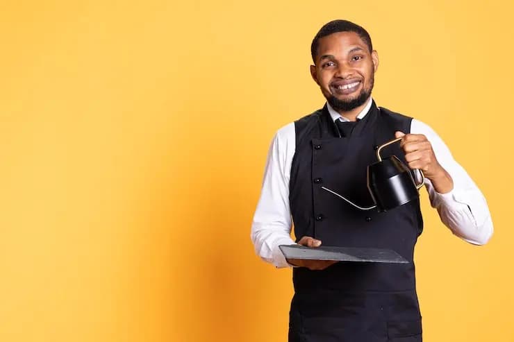 Serveur apportant une théière à la table de clients pour leur servir le thé