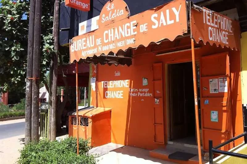 Boutique de téléphonie et bureau de change orange à Saly, avec l'enseigne « Cartes orange, vente portables »