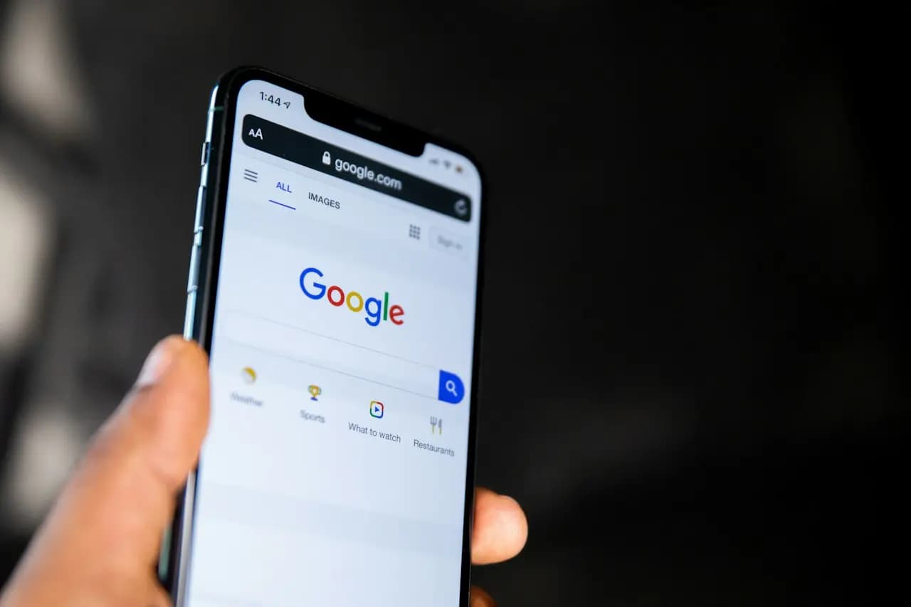 Main tenant un smartphone affichant la page de recherche Google
